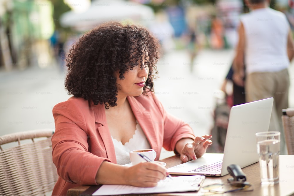 Business woman sitting in café and using laptop.