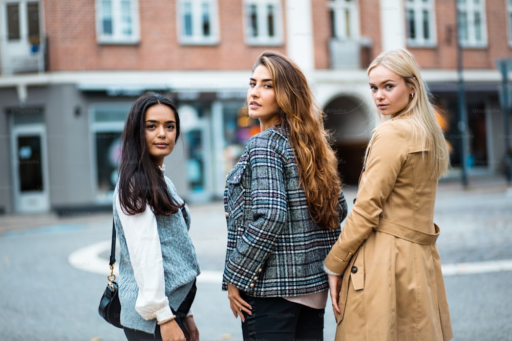 Portrait of three women standing on street and looking at camera.