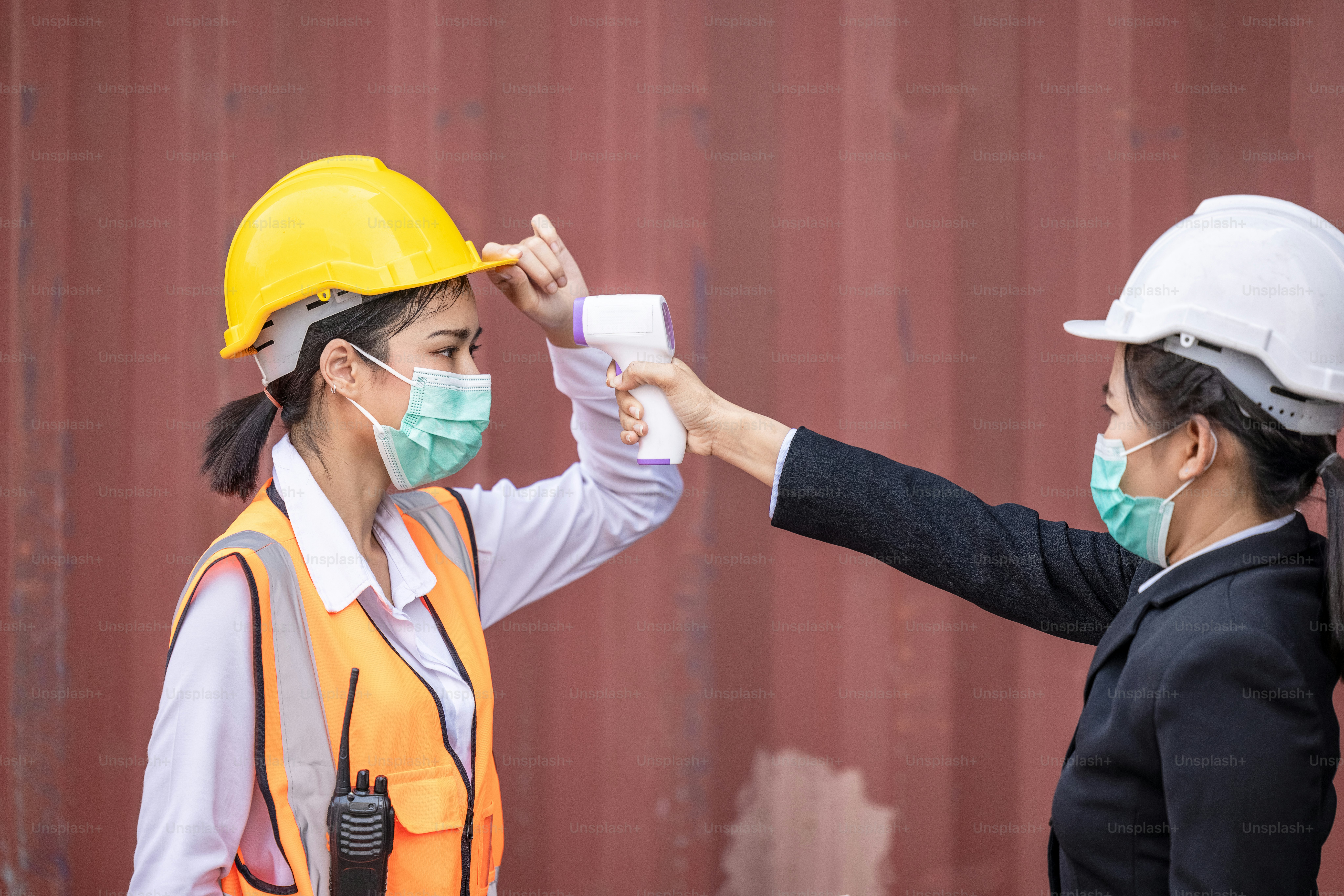 Situation de crise épidémique de maladie Covid-19 à coronavirus, travailleur du transport maritime de conteneurs ayant de la fièvre balayage corporel par balayage du thermomètre
