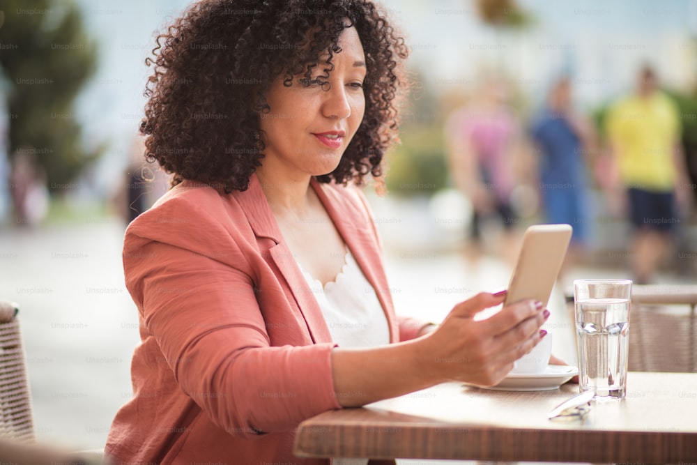 Mujer en el café usando un teléfono inteligente.