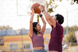 Couple standing on court. Girl holding ball for basket.