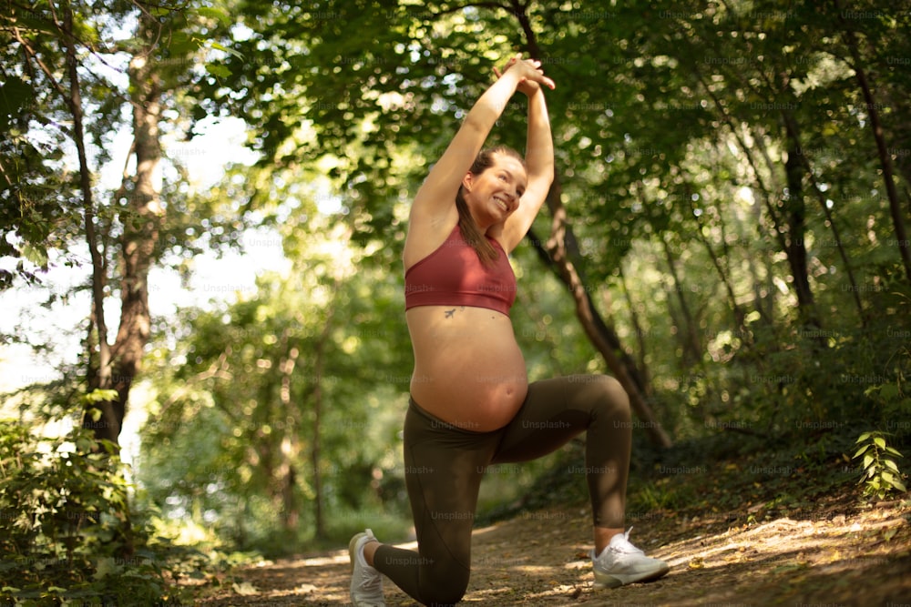 Pregnant woman working exercise in the forest.