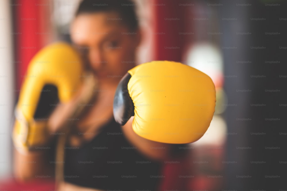 Mujer boxeadora con guantes de boxeo. El enfoque está al alcance de la mano.