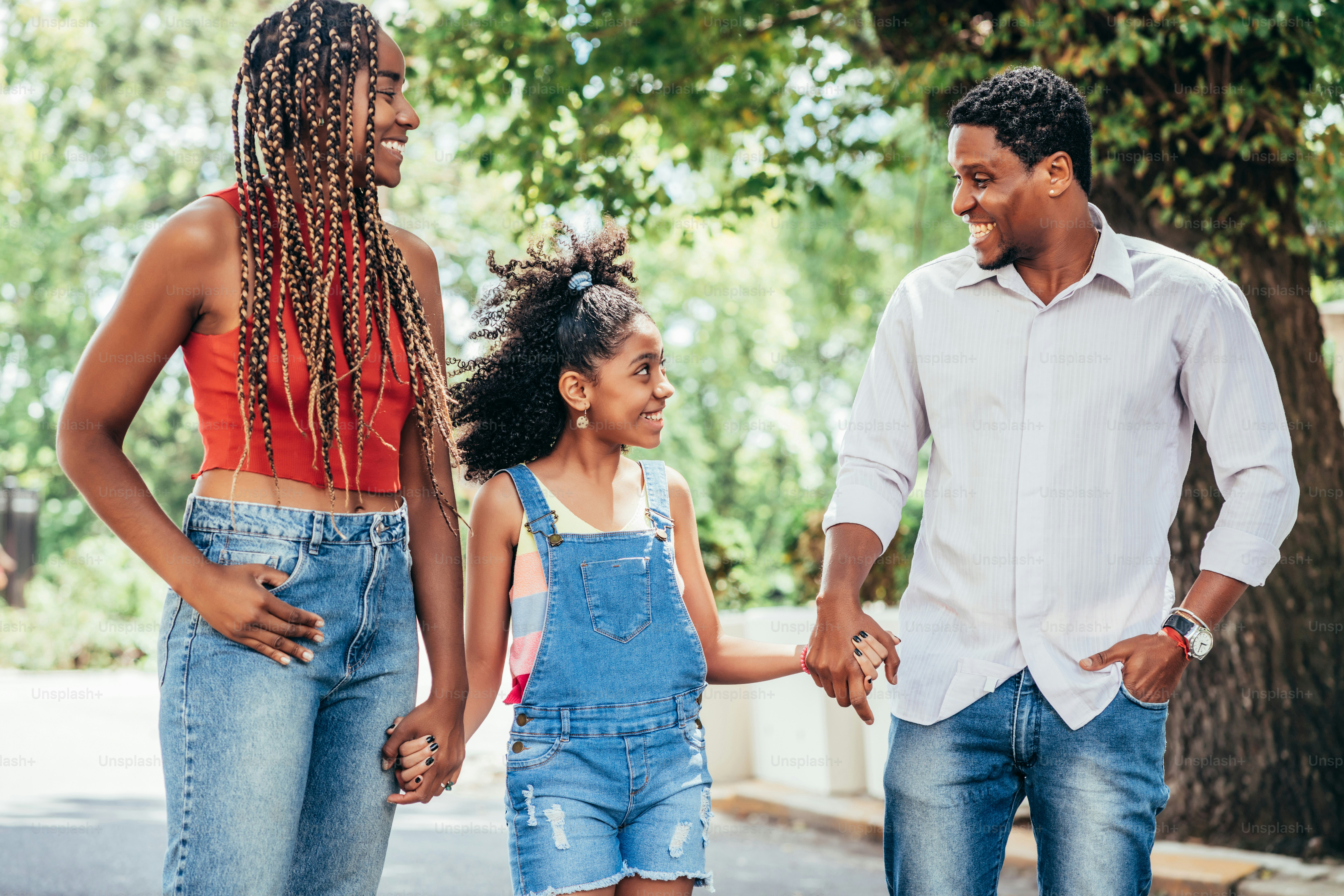 African American family enjoying a walk together outdoors on the street.