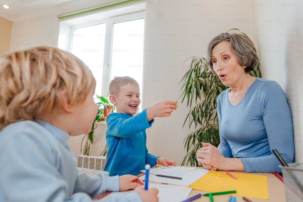 Boys playing with his grandmother with dinosaur toys in the kids room. Selective focus.