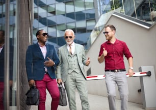 Three business men walking and talking outside.