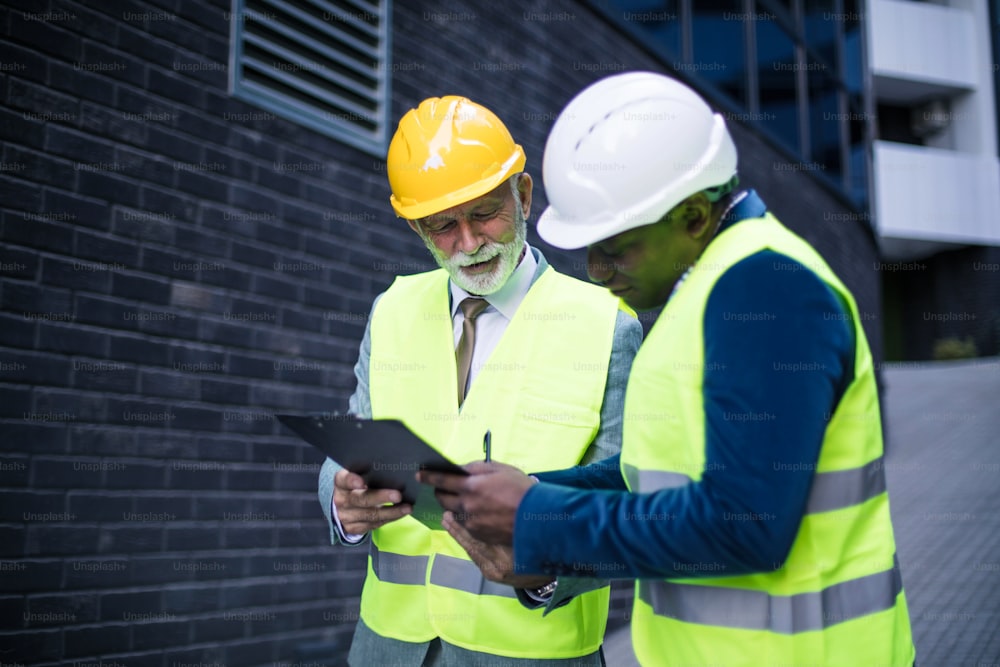 Two business architects on street reading document.