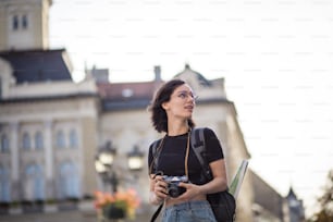 Jeune femme prenant une photo dans la ville avec un appareil photo.