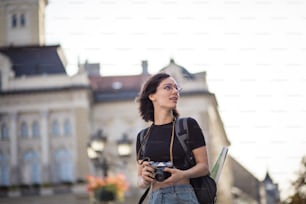 Young woman taking photo in the city with camera.