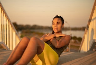 African sports woman doing crunch. Focus is on background.