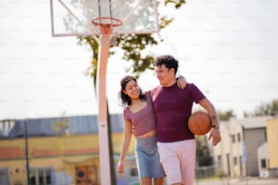 Paar mit Ball auf Basketballplatz.