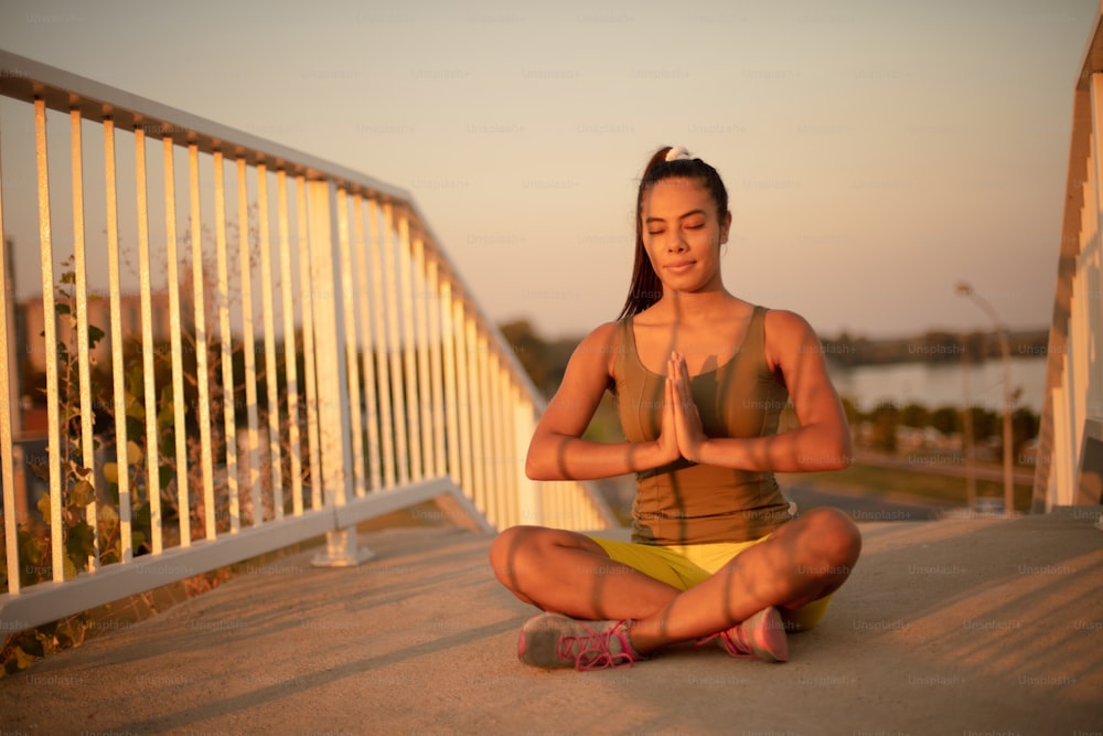 African woman working yoga on the bridge.