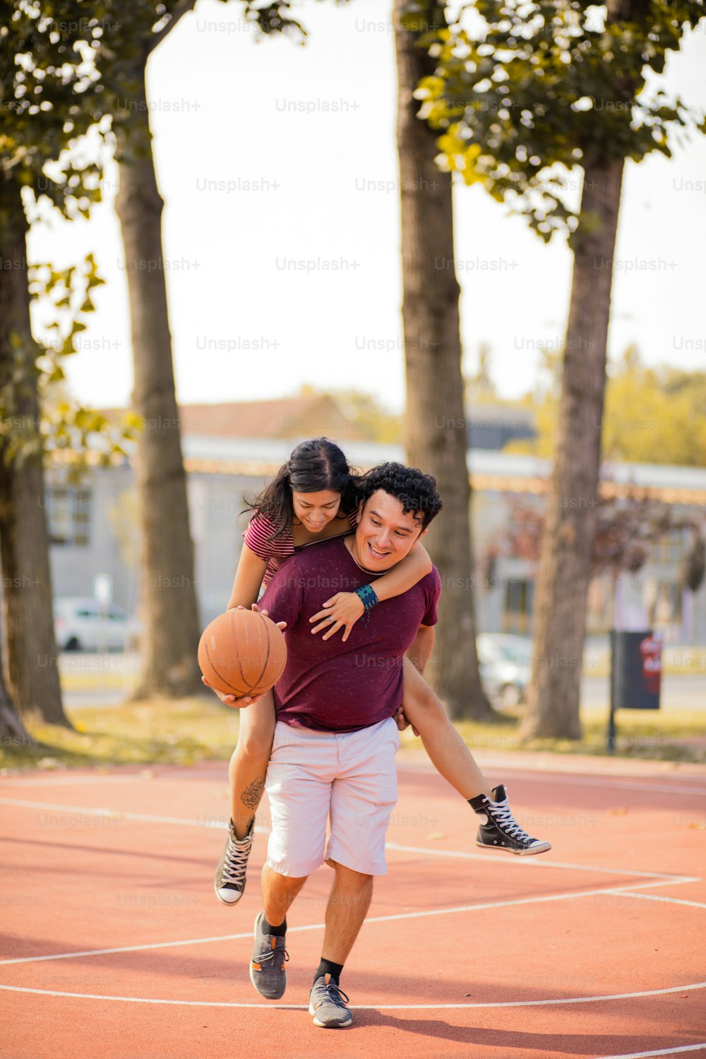 Joven pareja feliz jugando al baloncesto.