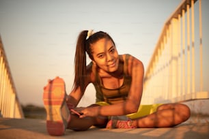 다리에서 운동을 하는 아프리카 스포츠 여성. 초점은 배경에 있습니다.