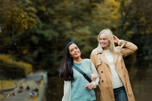 Two young girls walking trough park and talking.