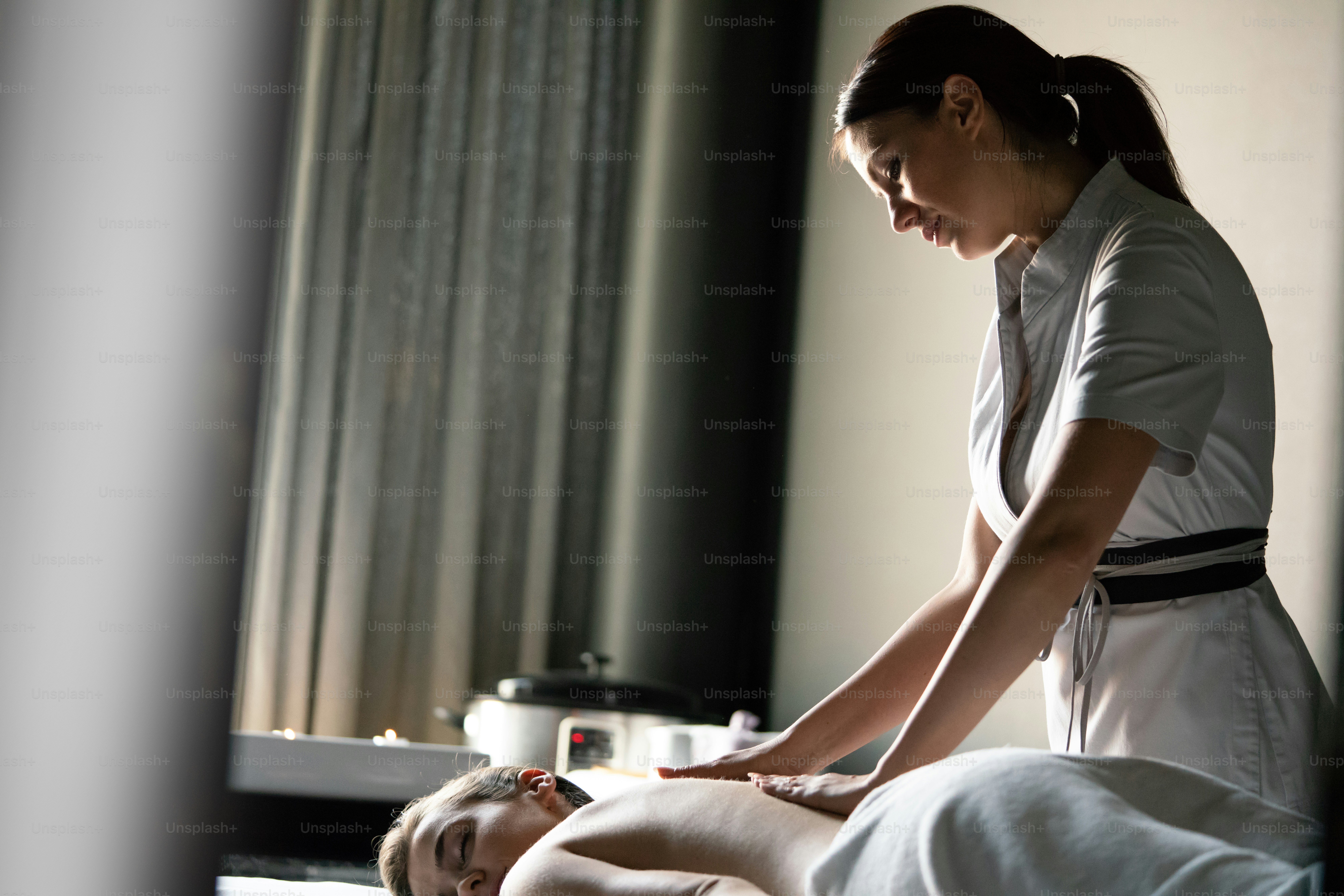 Wanita muda yang menarik di salon spa sedang dipijat