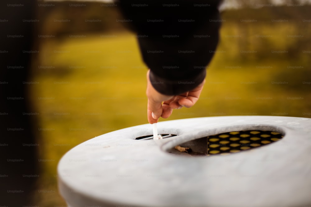 Man puts out a cigarette. Focus is on hand.