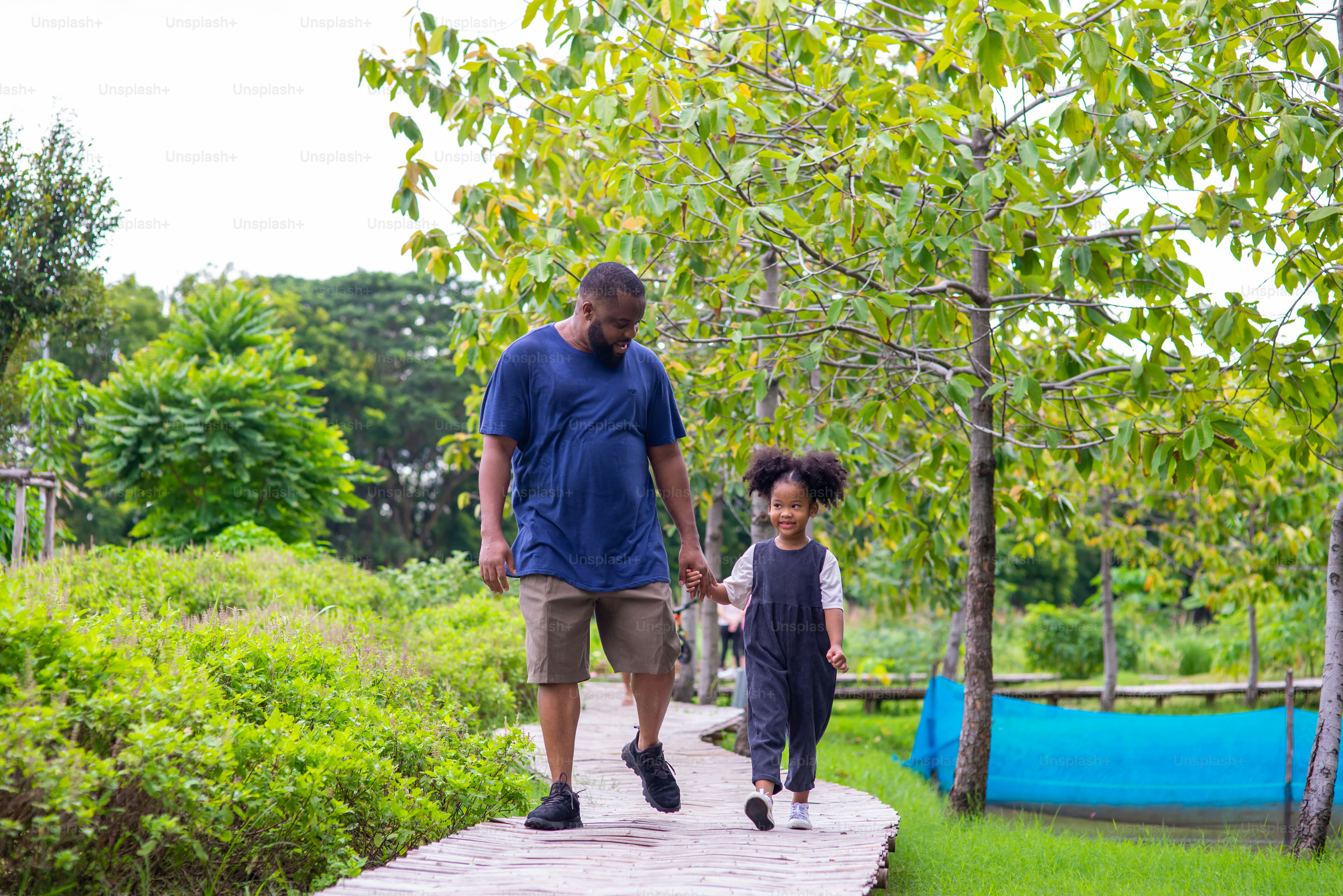 Feliz familia de raza mixta en el parque. Padre africano con una hija ...