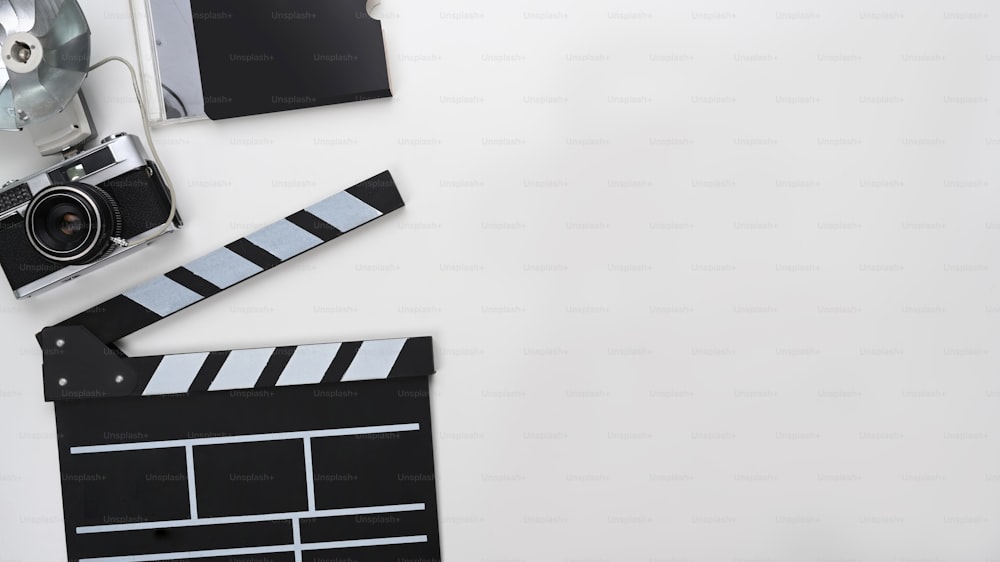Clapboard, camera and copy space on white background.