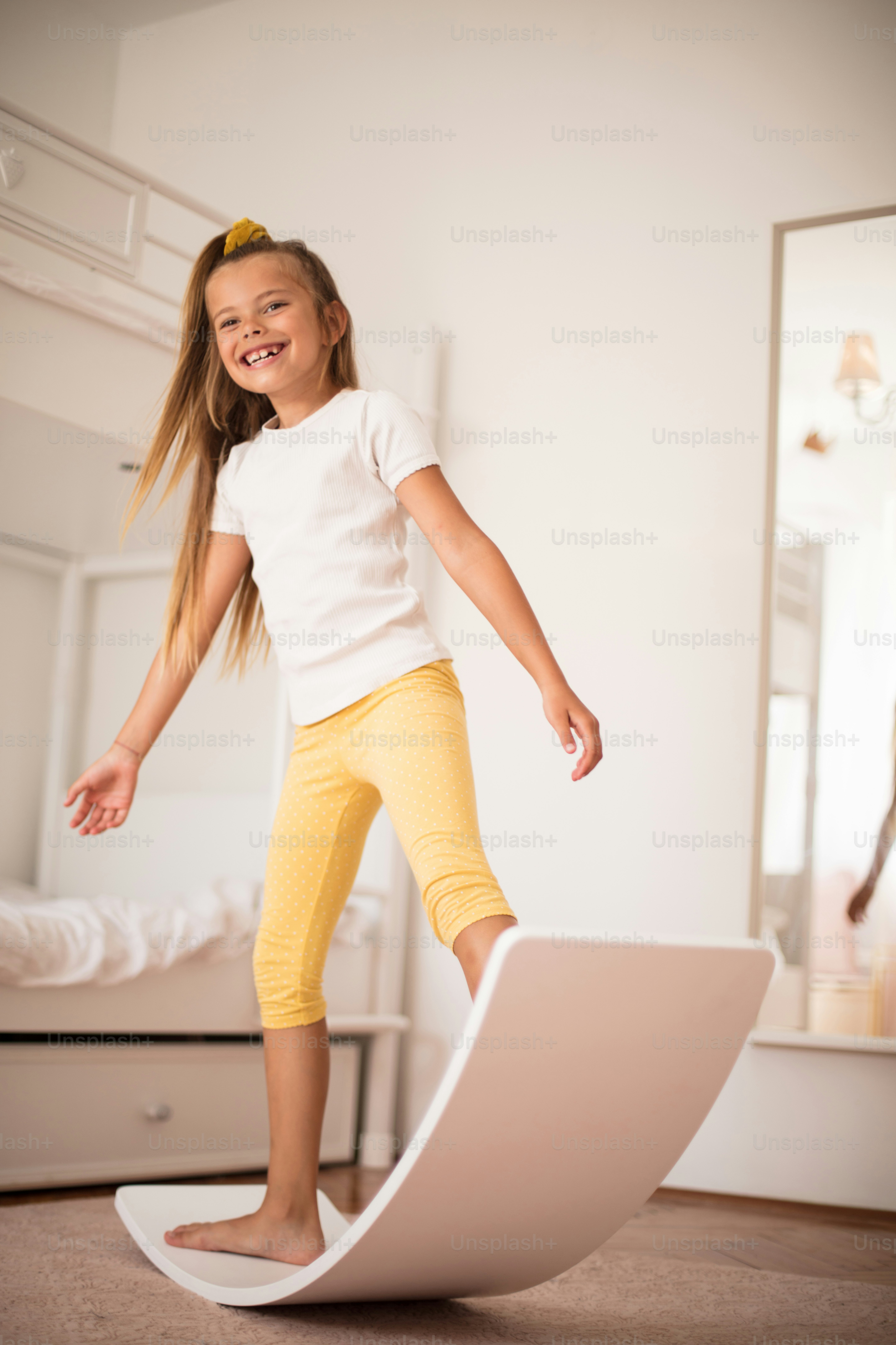 Smiling little girl playing in bedroom alone.