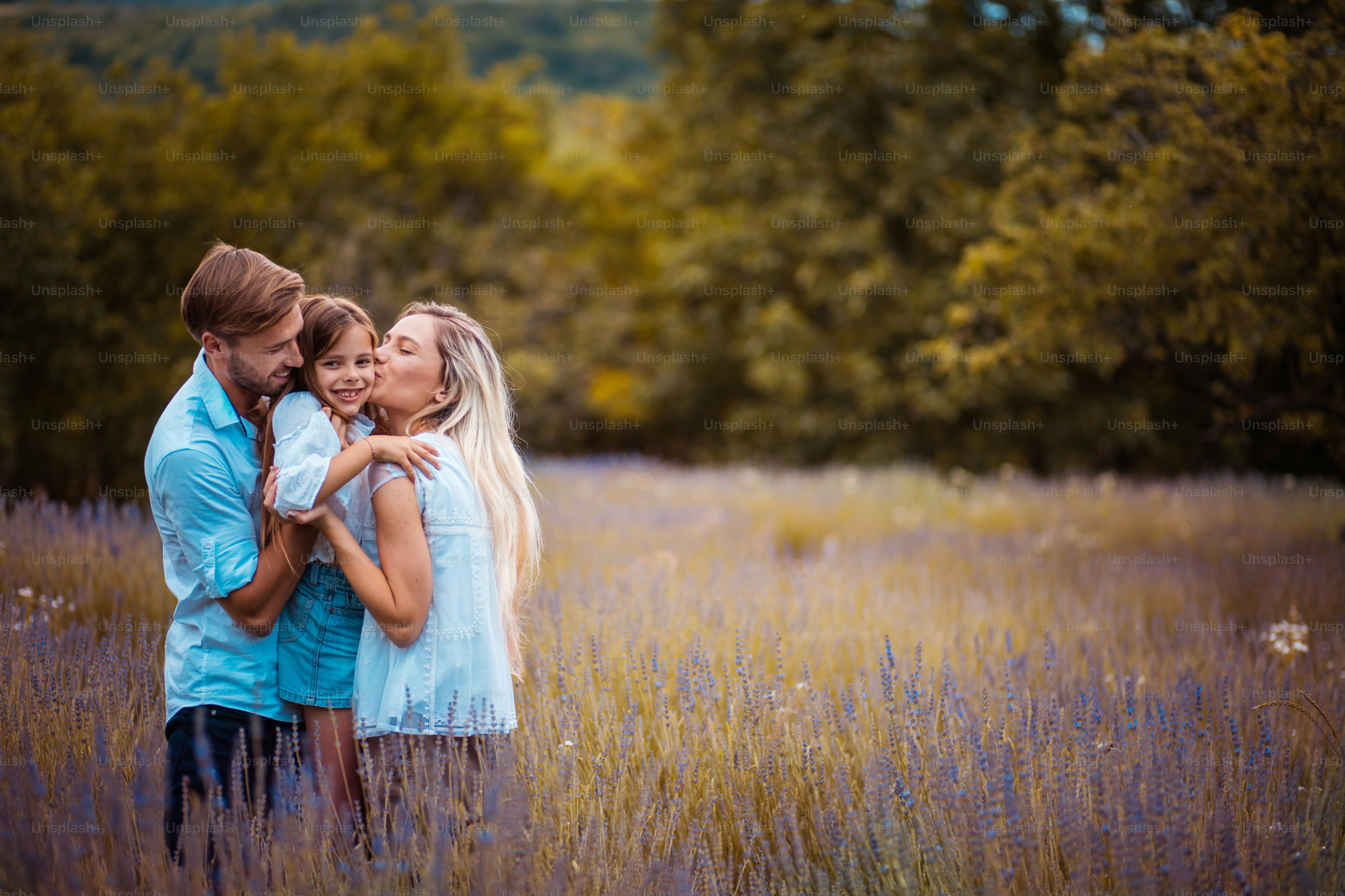 Foto Familia feliz en el campo de lavanda. Madre besando a su hija ...
