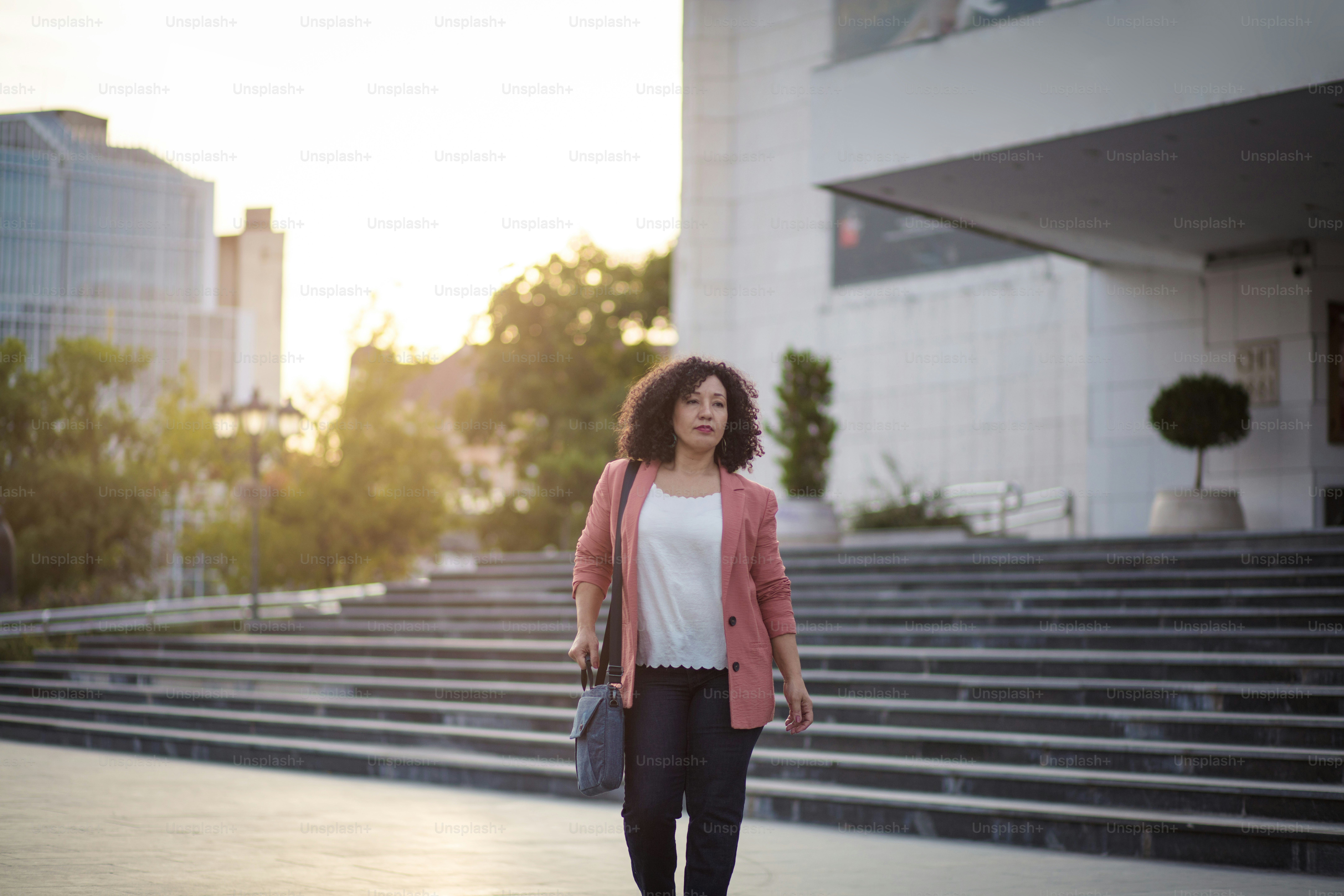 Time to go home after work.  Business woman walking trough city alone.