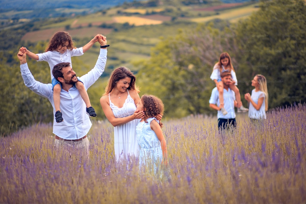 Large group of people in lavender field. Focus is on foreground.