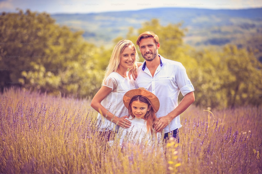 Porträt einer lächelnden Familie im Lavendelfeld.