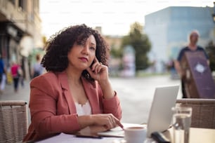 Business woman sitting in café and using laptop.  It's time for a business change.