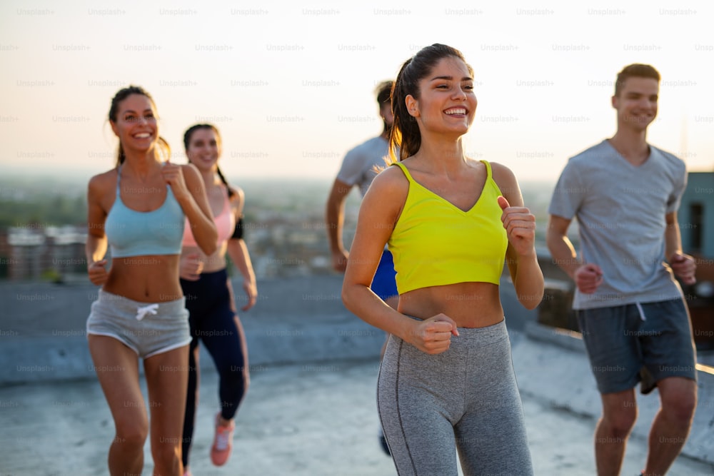 Group of happy fit people exercising together outdoor