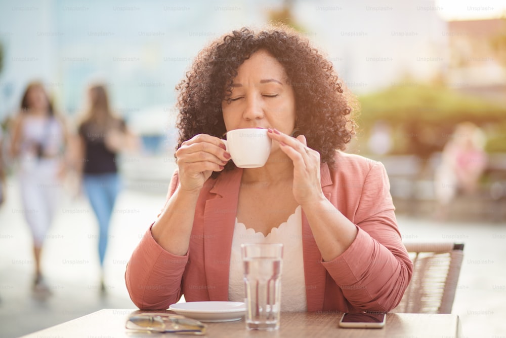 コーヒータイム。 路上でコーヒーを飲む女性の肖像画。