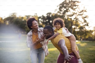Happy black parents having fun with their daughter at the park. African American family having fun outdoors.