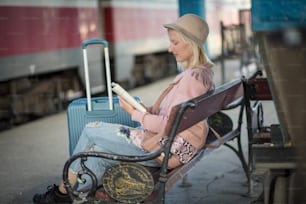 駅で本を読む女性。