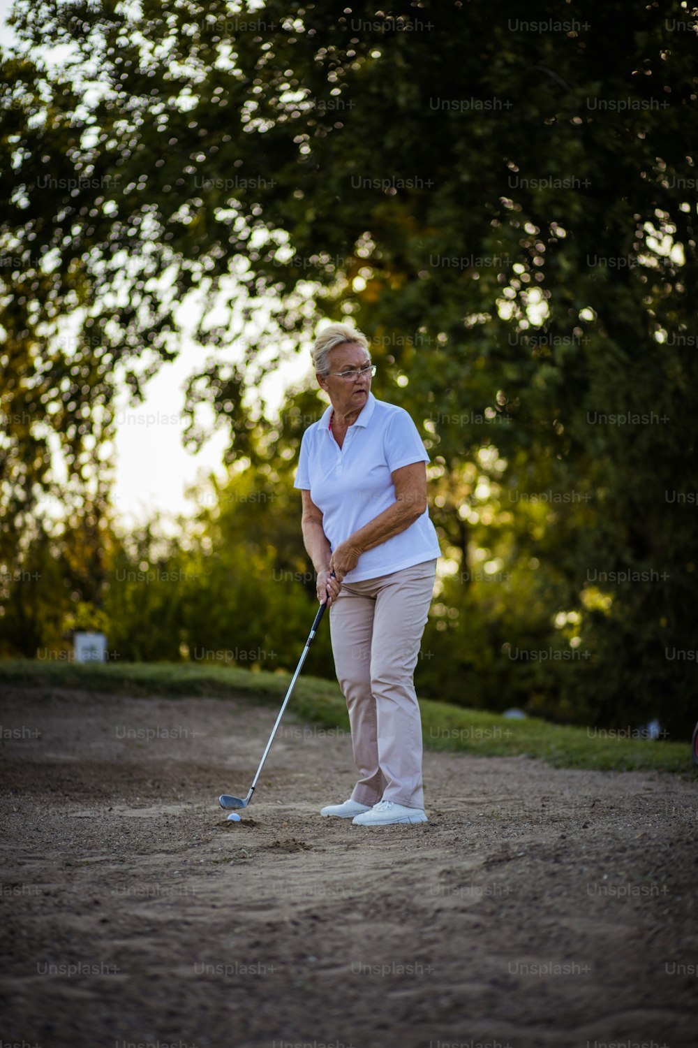 Senior woman playing golf. Golfer.