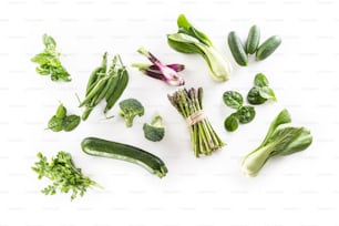 Assorment of fresh green vegetables isolated on white background.