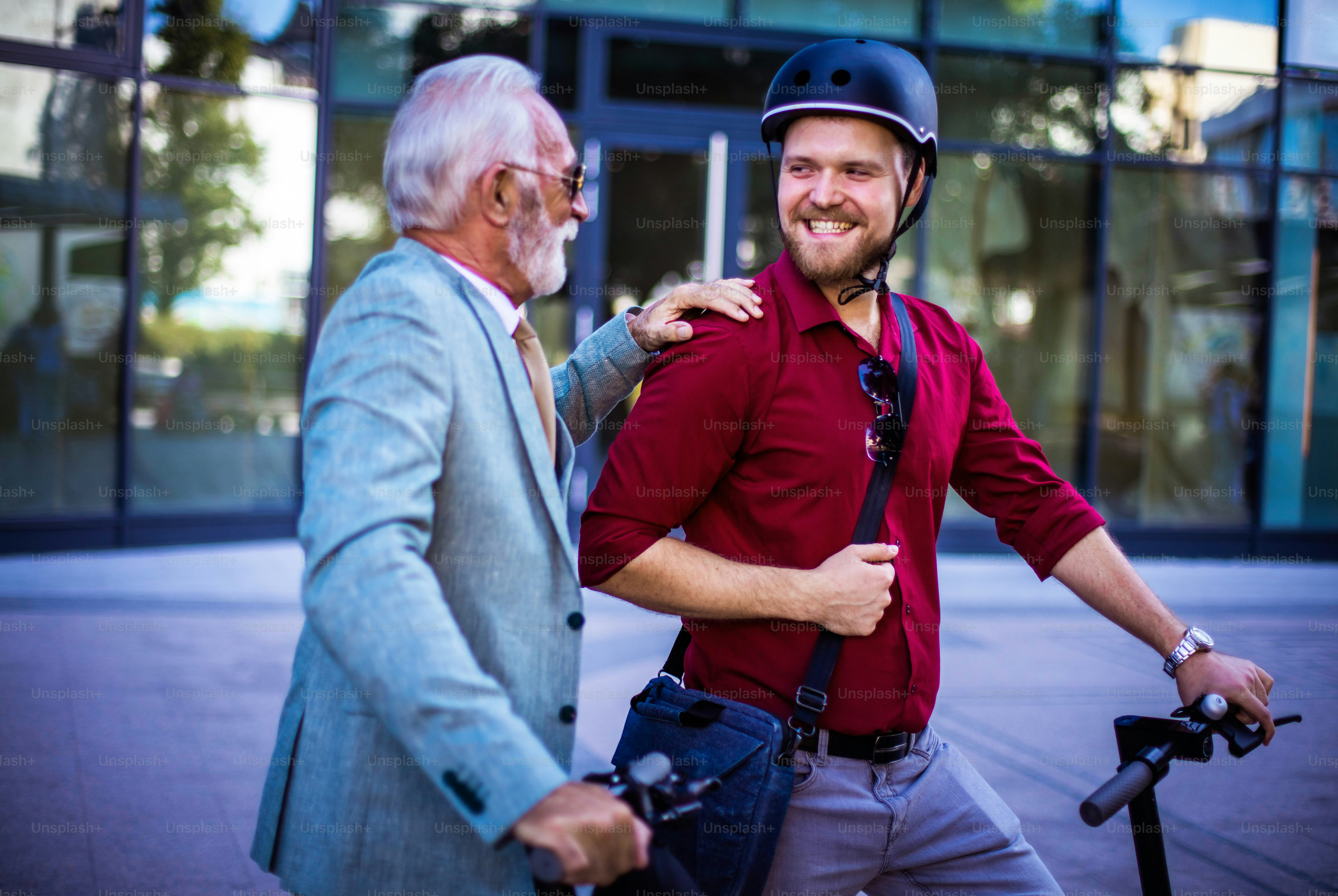 Two business men riding electric scooter in the city. photo – Outdoor ...
