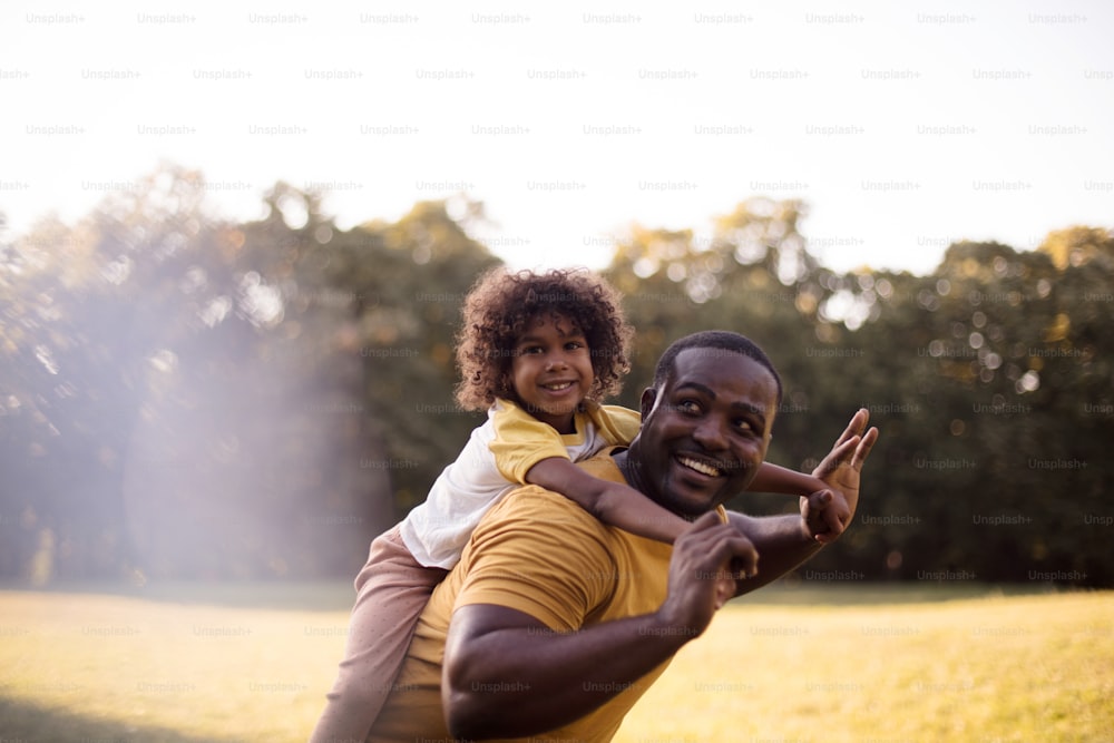 Para pai e filha, a diversão está sempre lá.  Pai e filha afro-americanos se divertindo ao ar livre.
