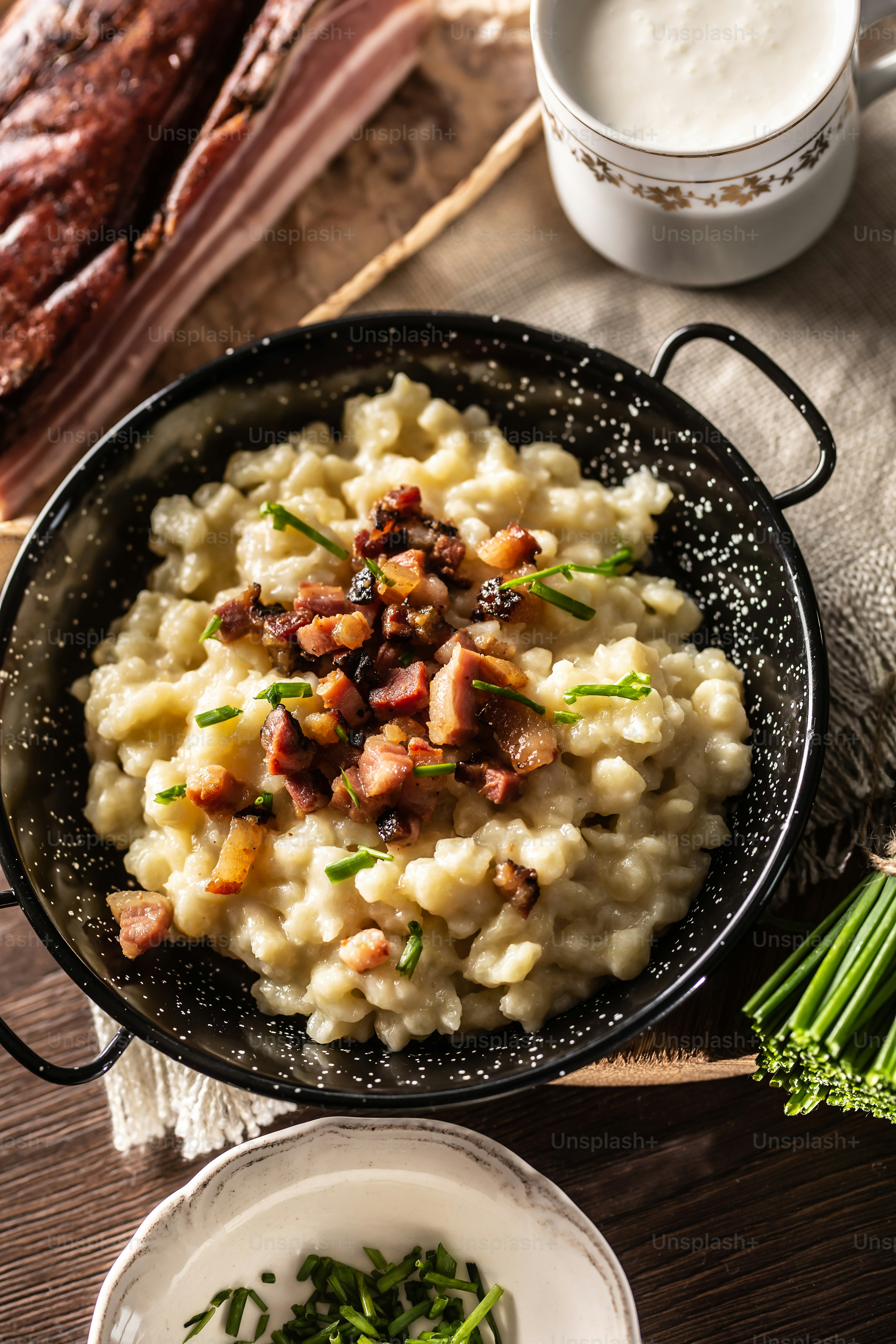Top view of typical Slovakian food halusky with bryndza cheese, topped with bacon and chives.