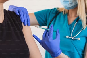 患者の肩に注射やワクチンを接種する女性医師や看護師。インフルエンザやウイルスのパンデミックに対する予防接種と予防。ワクチン接種のコンセプト