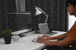 Side view of programmer working in software develop company office.