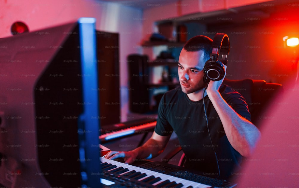 Engenheiro de som profissional trabalhando e mixando música dentro de casa no estúdio.