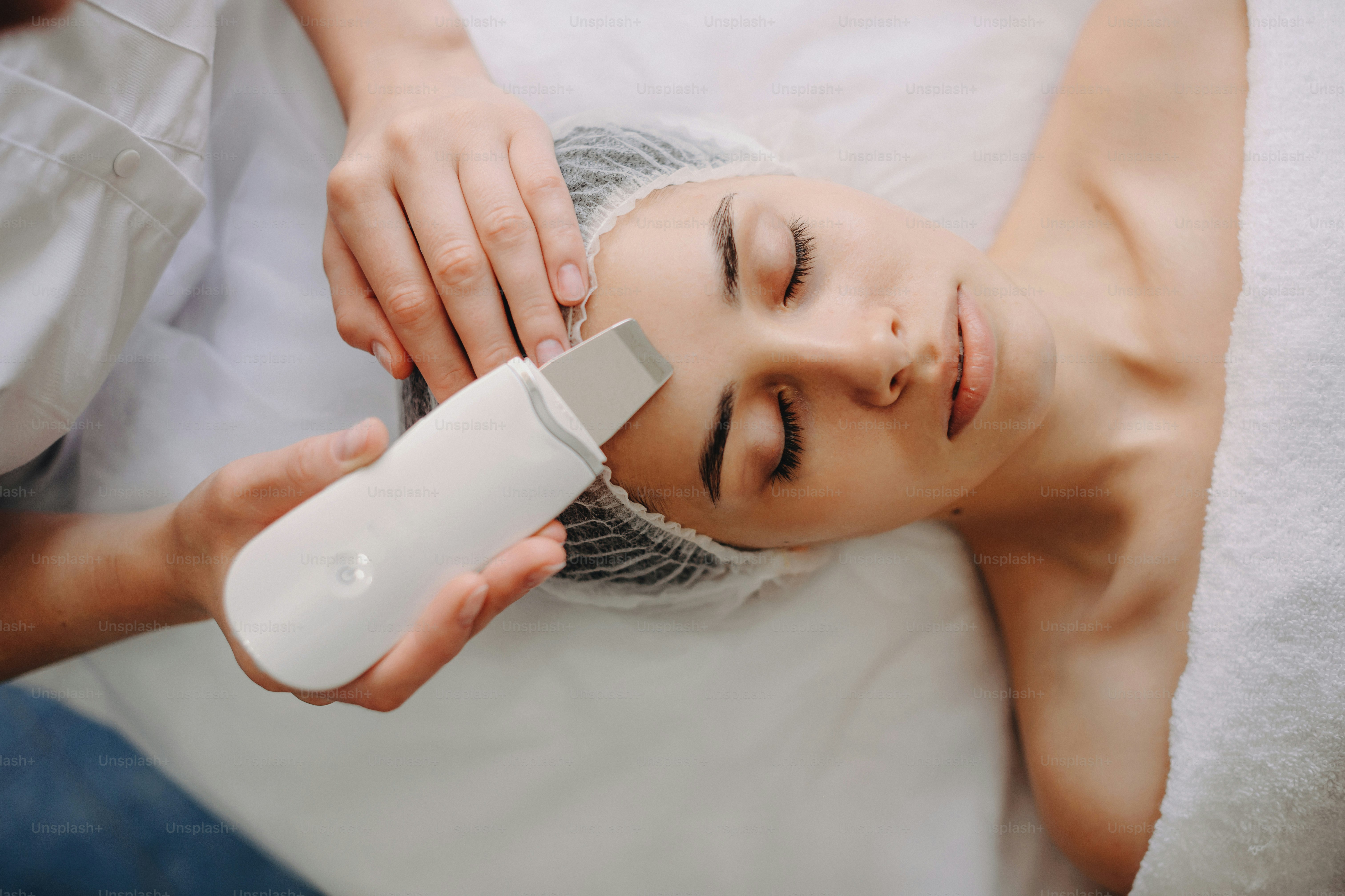 Photo de vue de dessus d’une femme caucasienne allongée tout en subissant des procédures de spa professionnelles avec un appareil au salon