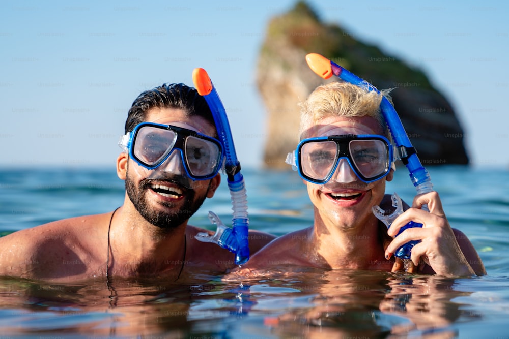 Group of happy friends go scuba diving together on summer vacation