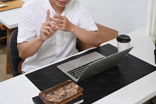 Abgeschnittener Sot des Geschäftsmannes mit Videoanruf mit Geschäftspartner auf Laptop-Computer.