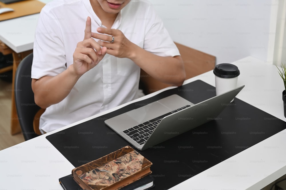Cropped sot of businessman having video call with business partner on laptop computer.