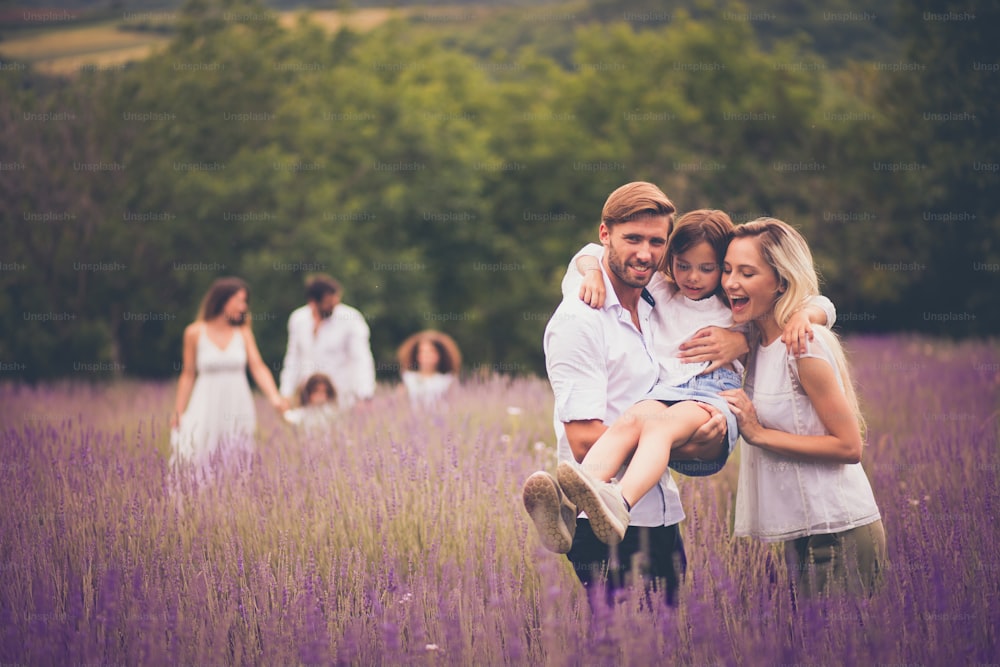 Large group of people in lavender field. Focus is on foreground.