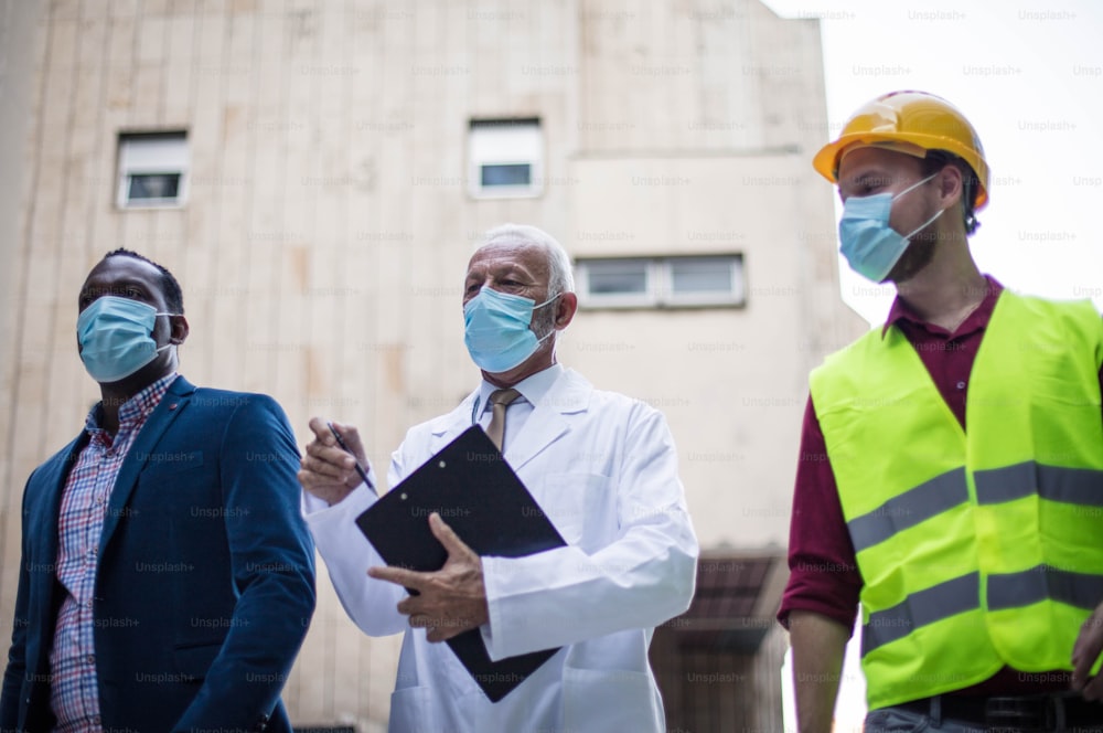 Hombre de negocios, médico e ingeniero caminando por la calle.