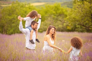 Family in lavender field. Father carrying his son shoulders.