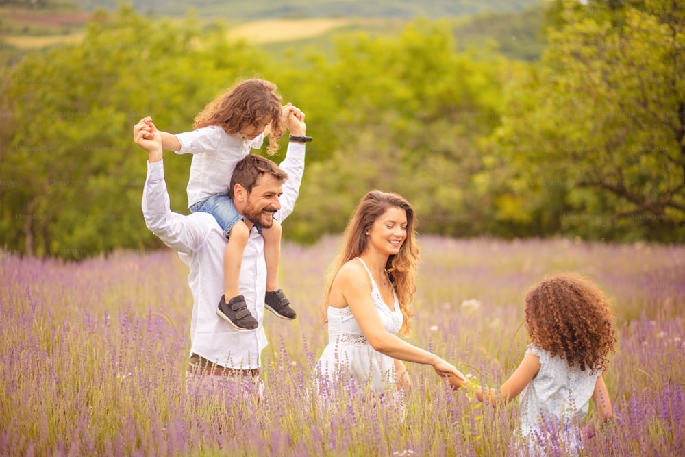 Family in lavender field. Father carrying his son shoulders.