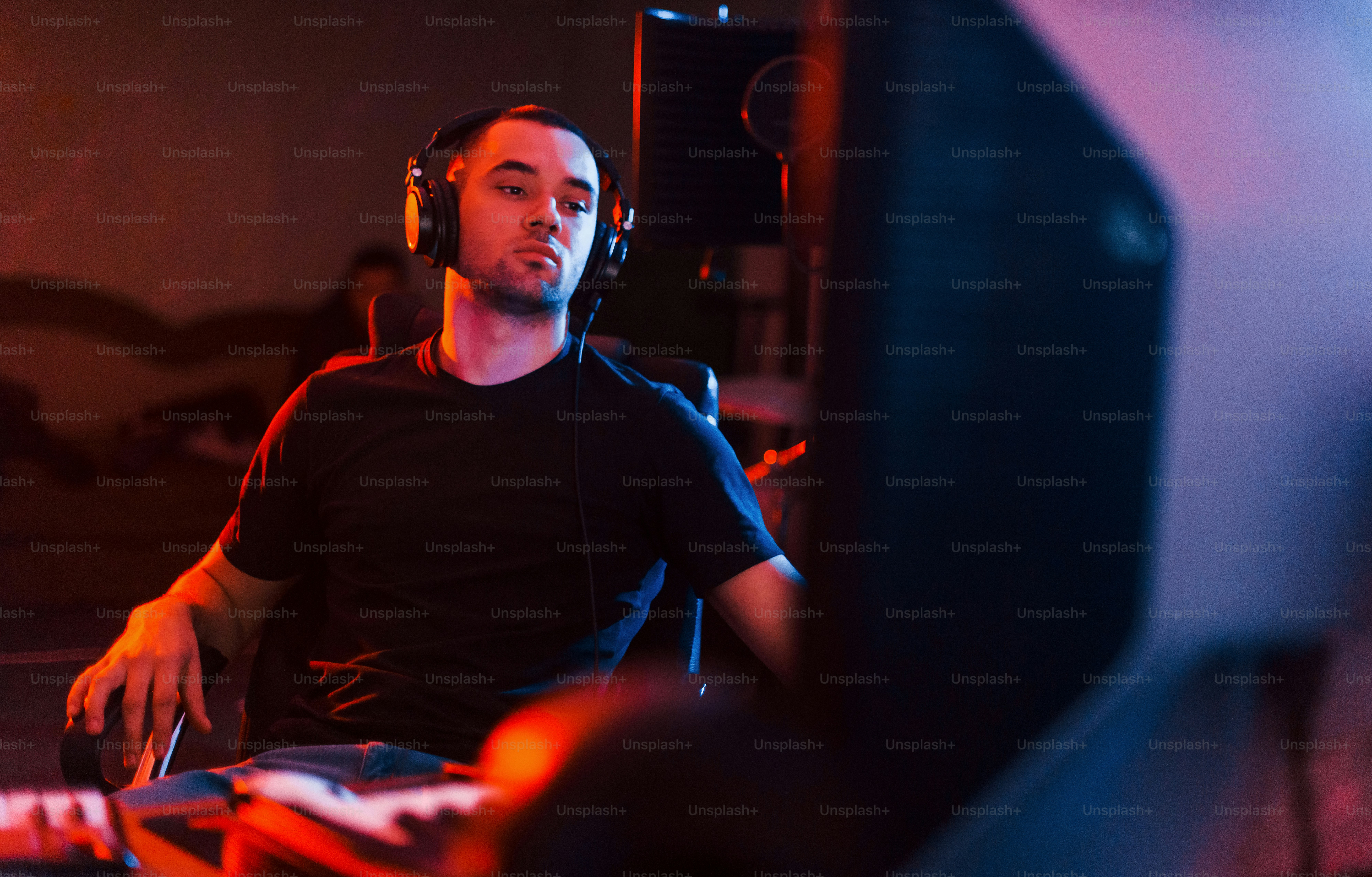 Sound engineer in headphones working and mixing music indoors in the studio.